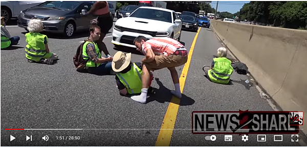 Ein Mann auf Bewährung, bittet Klimaaktivisten, die die Autobahn blockieren, ihm eine Spur freizugeben.